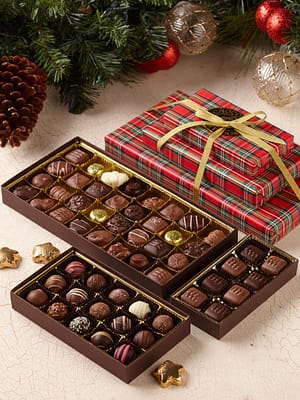 Tartan Tower is 3 chocolate assortments wrapped in plaid paper stacked as a gift
